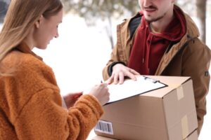 Assurance colis : livreur faisant signer un bordereau de réception à une cliente pour certifier la bonne livraison.